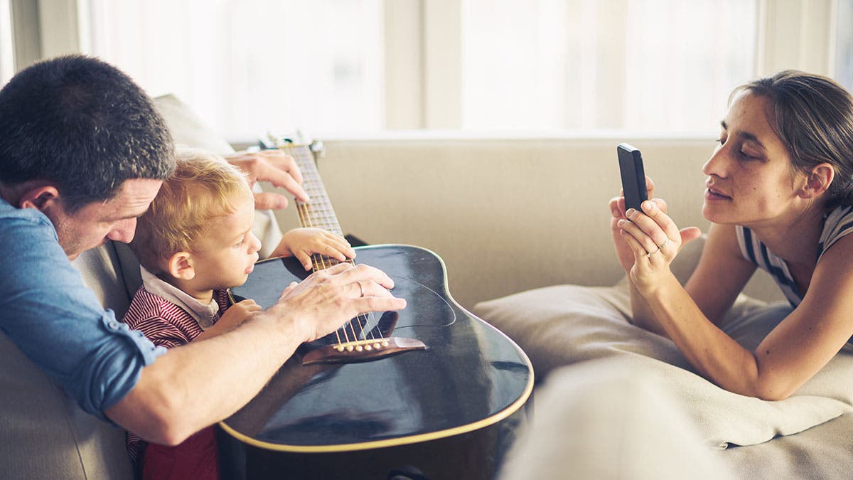 mother taking a picture of child with father