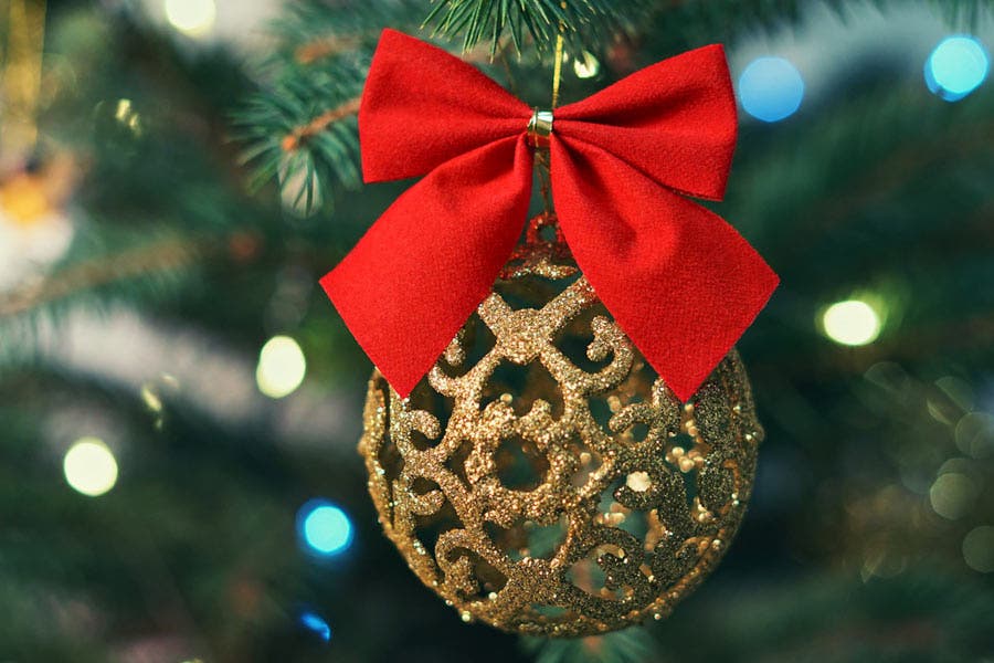 gold christmas tree ornament with big red bow