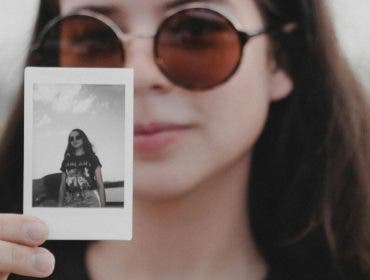 Woman holding image from instant camera